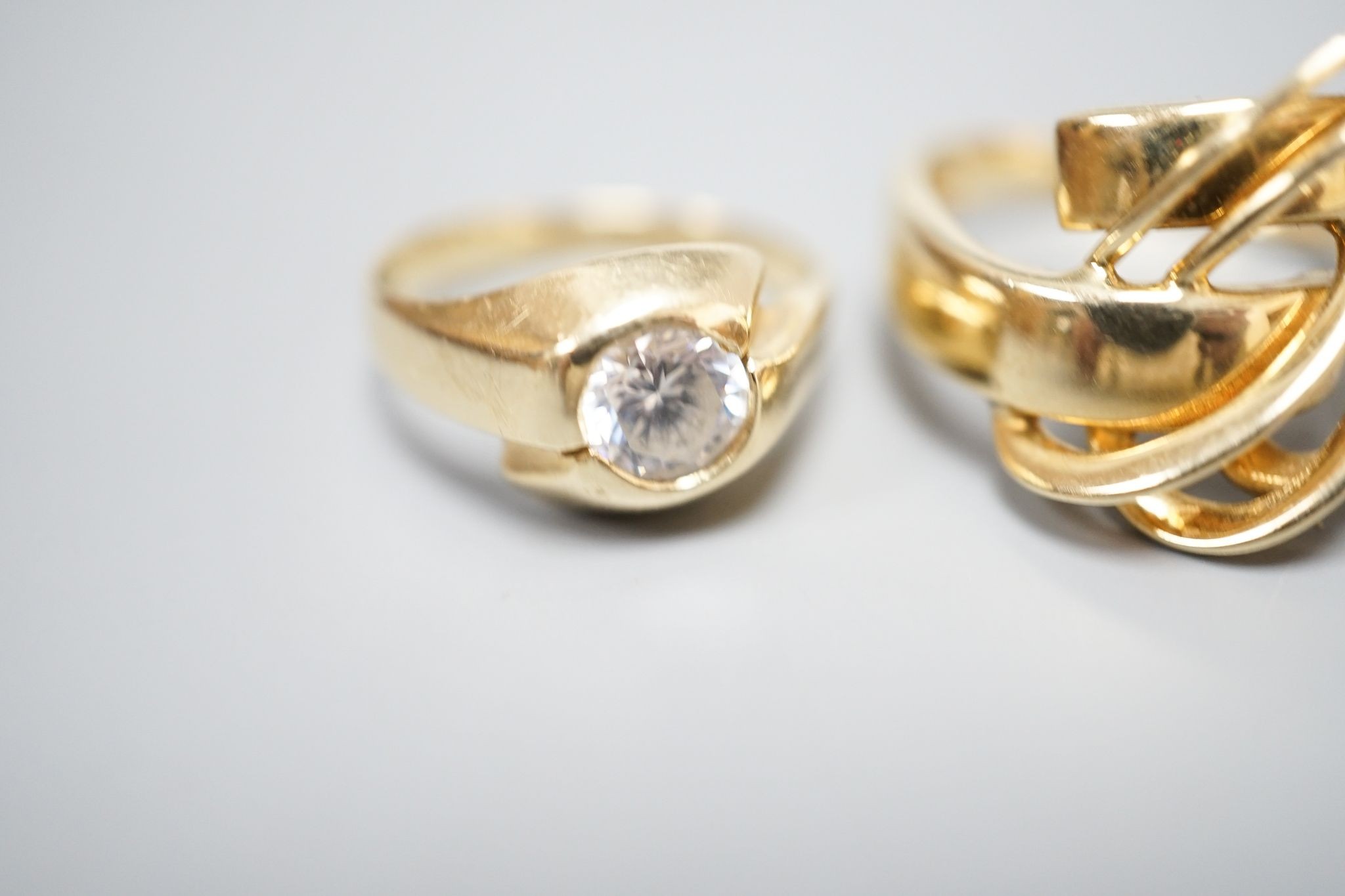 An Italian 750 scroll ring, size P, 5.5 grams and a 585 and white stone ring, gross 3.9 grams.